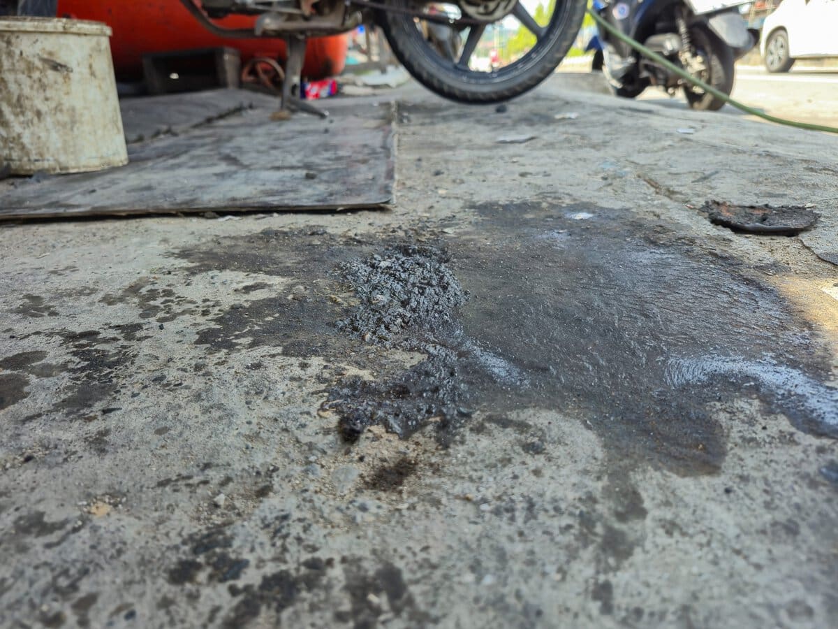Close-Up Of Engine Oil Spill On A Dirty Concrete Floor In A Motorcycle Repair Shop. Hazardous Slippery Leak In A Mechanic Garage, Representing Maintenance Waste And Workplace Safety Risks Adobestock 1888580731 Scaled - Bionetix®